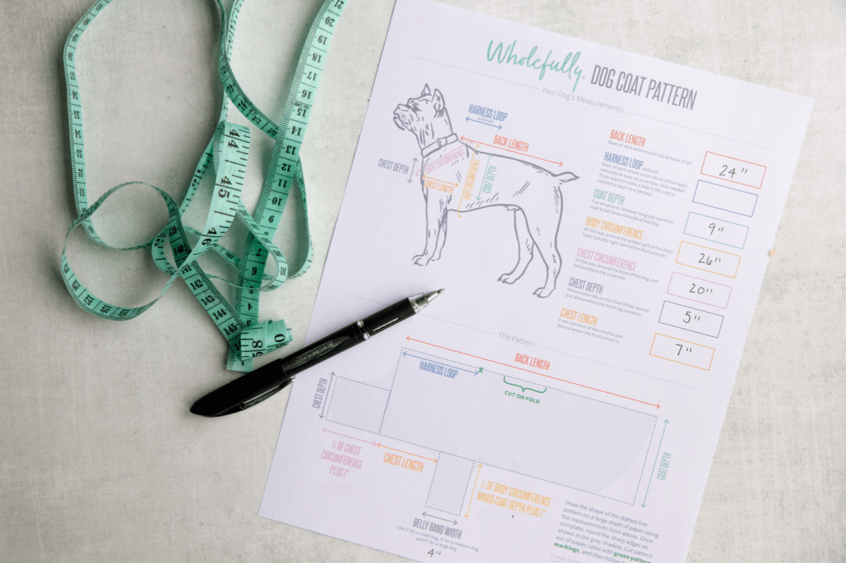 A measuring tape and pen sit beside a homemade pattern and measurement sheet.