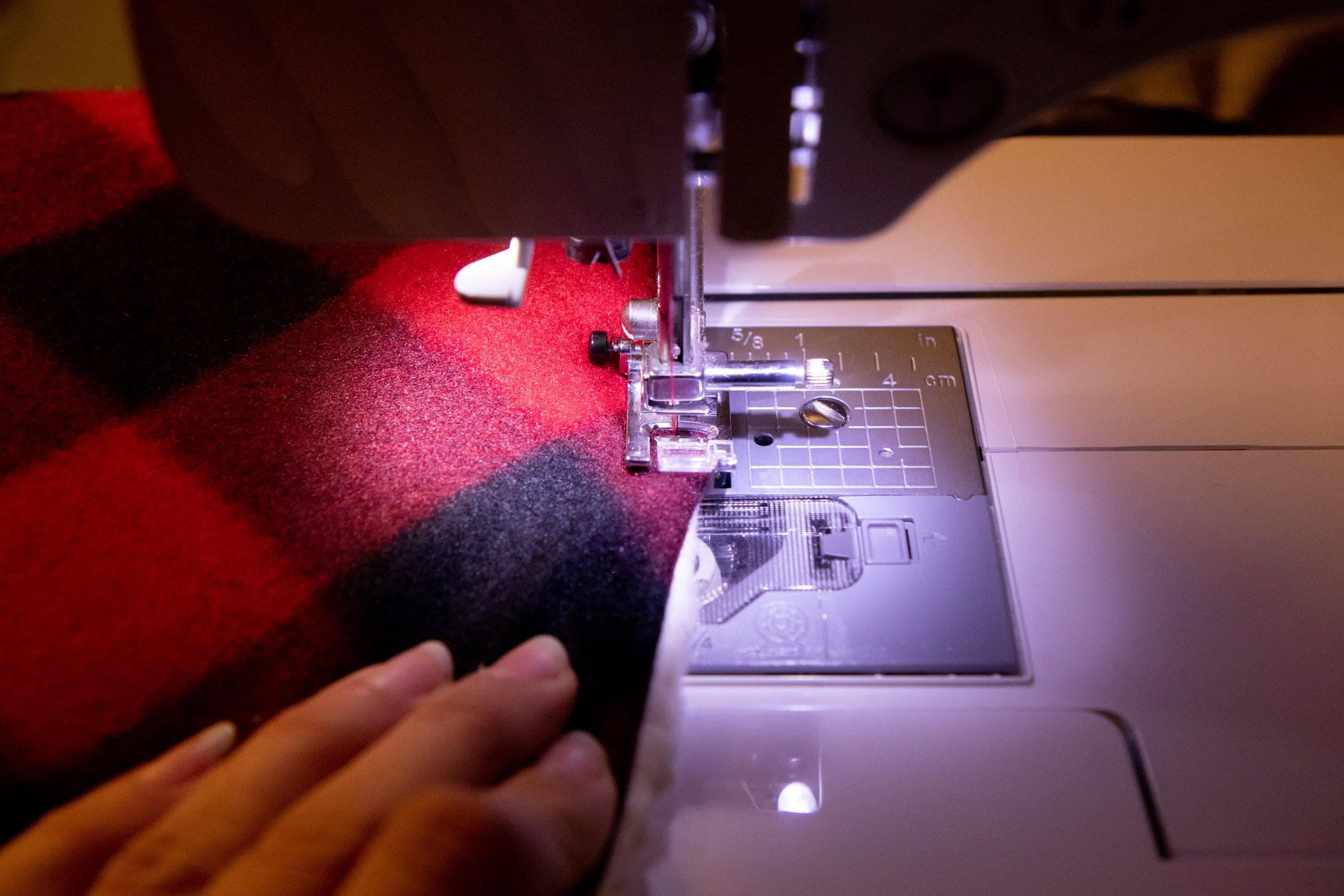 Plaid fabric being fed through a sewing machine